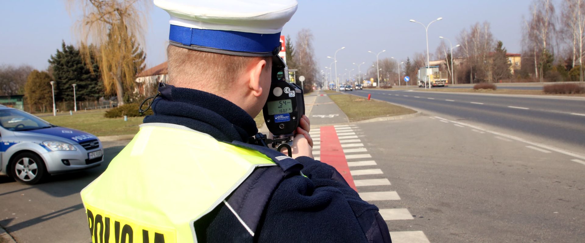 Policjant z radarem mierzący prędkość na drodze