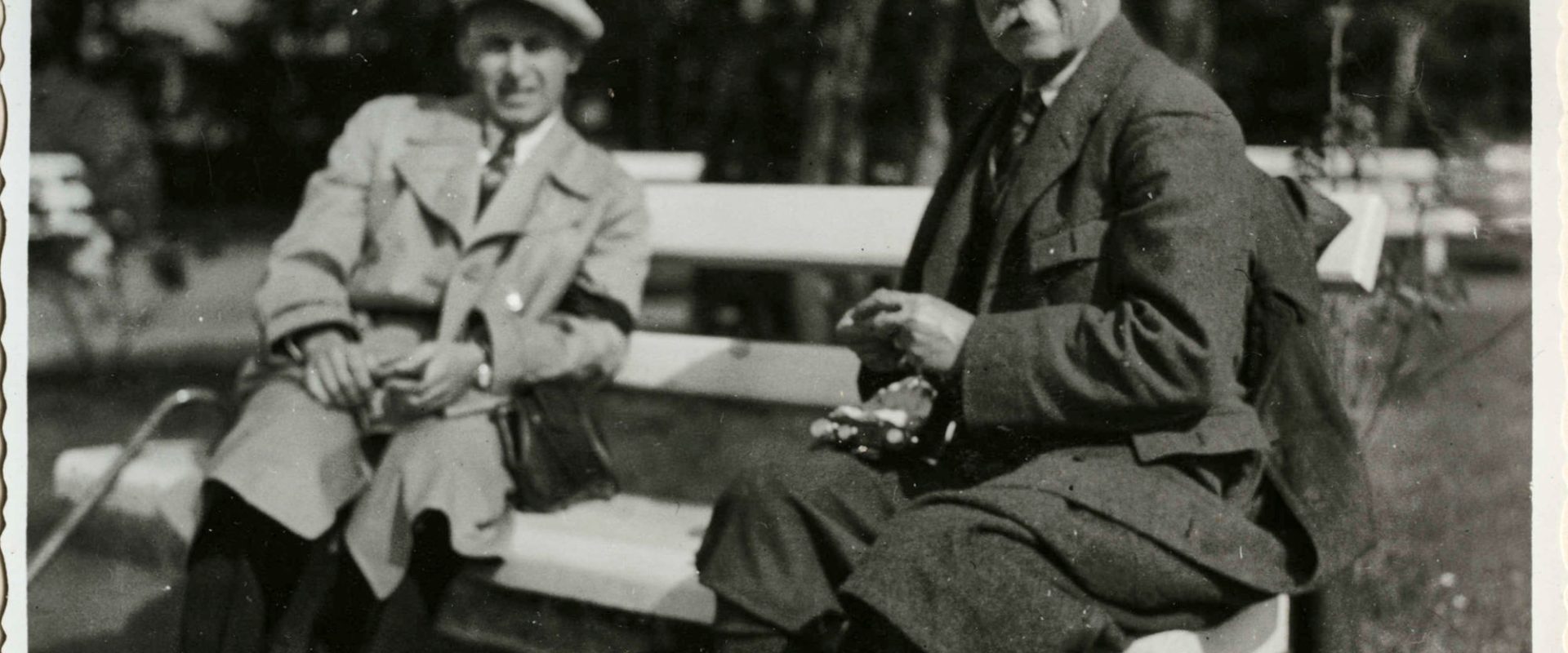 Na zdjęciu znajduje się dwóch mężczyzn siedzących na ławce w parku. Jeden z nich to książę Andrzej Lubomirski