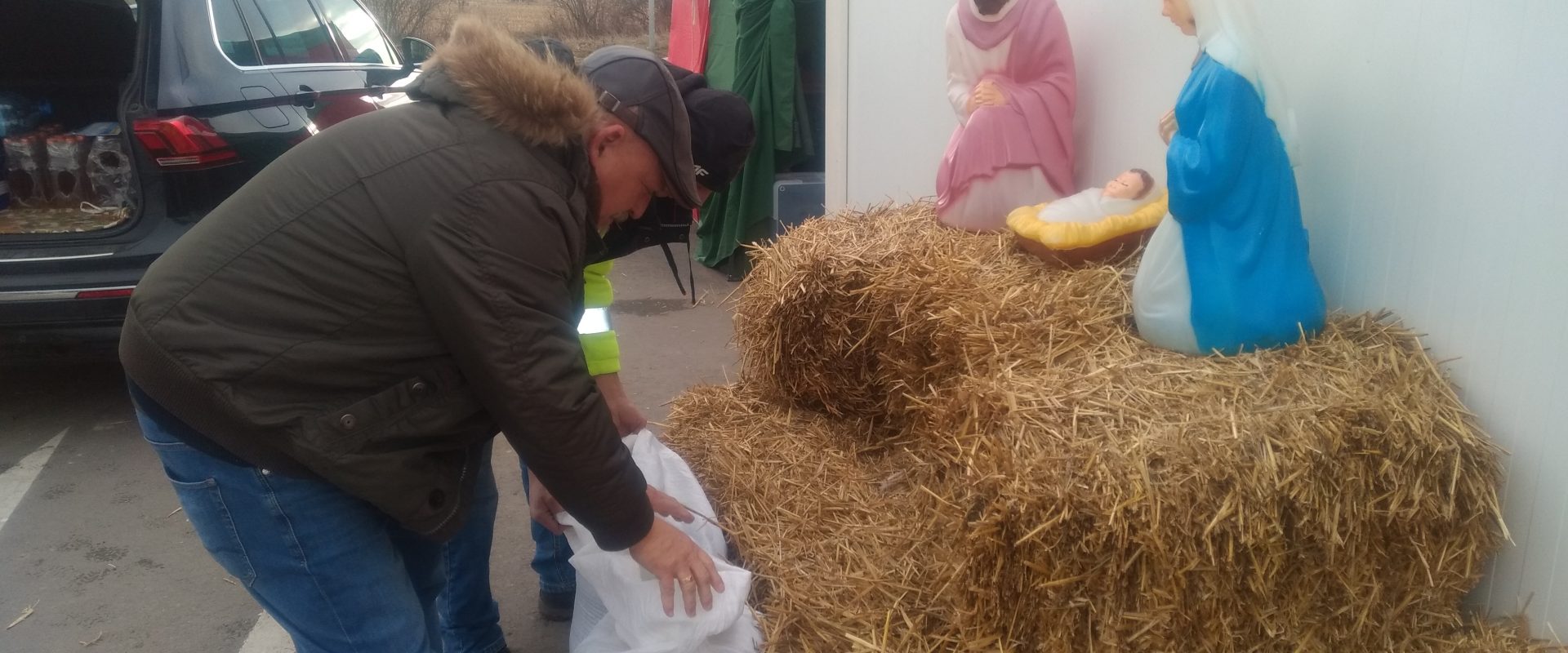 Rolnik przy sianku i prowizorycznej szopce bożonarodzeniowej