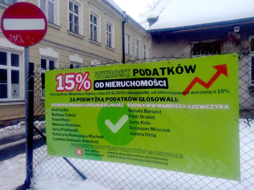 Zielony baner wiszący na jednym z ogrodzeń w Dębicy