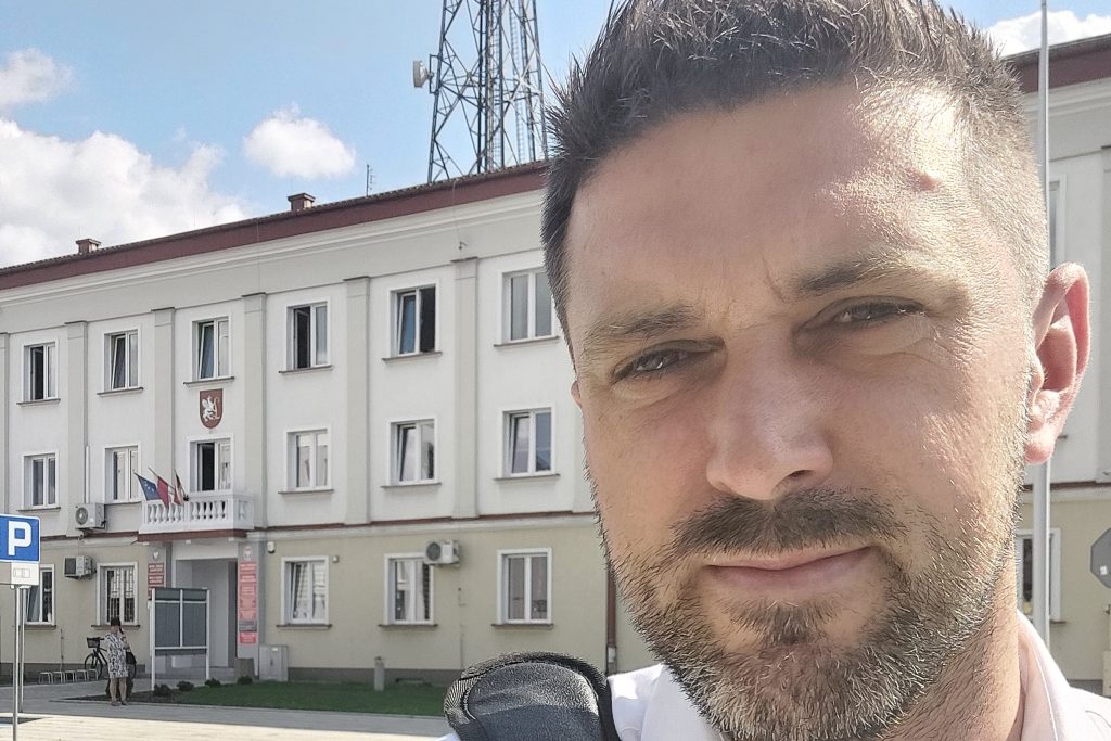 Marcin Piotrowski na tle budynków Lubaczowa